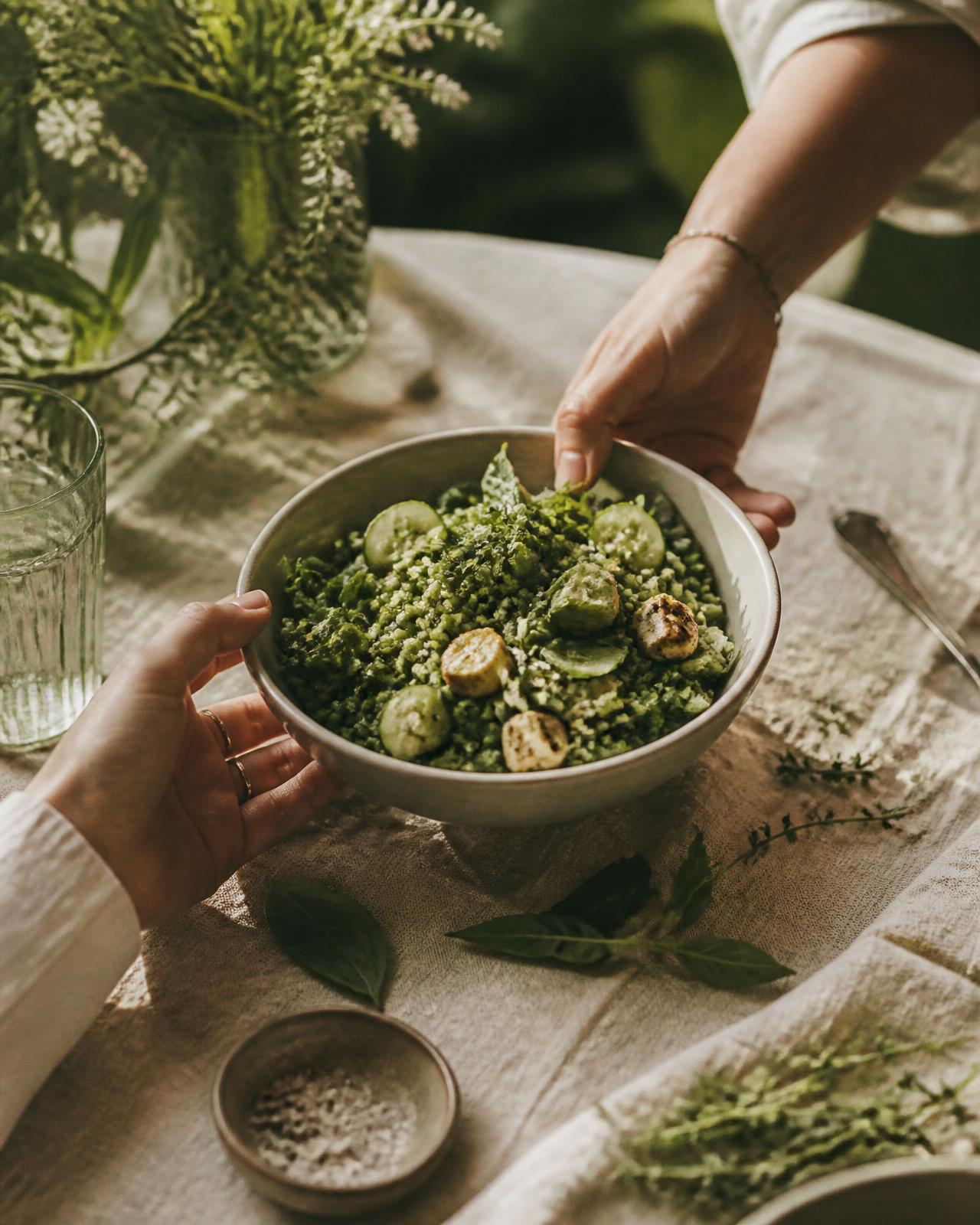 两个人在铺着亚麻桌布的餐桌旁分享一碗植物基料理